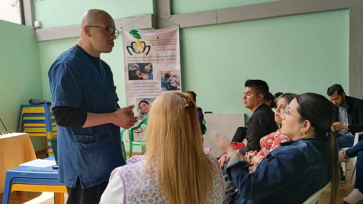 Conversación con asistentes durante una actividad de divulgación de salud oral.