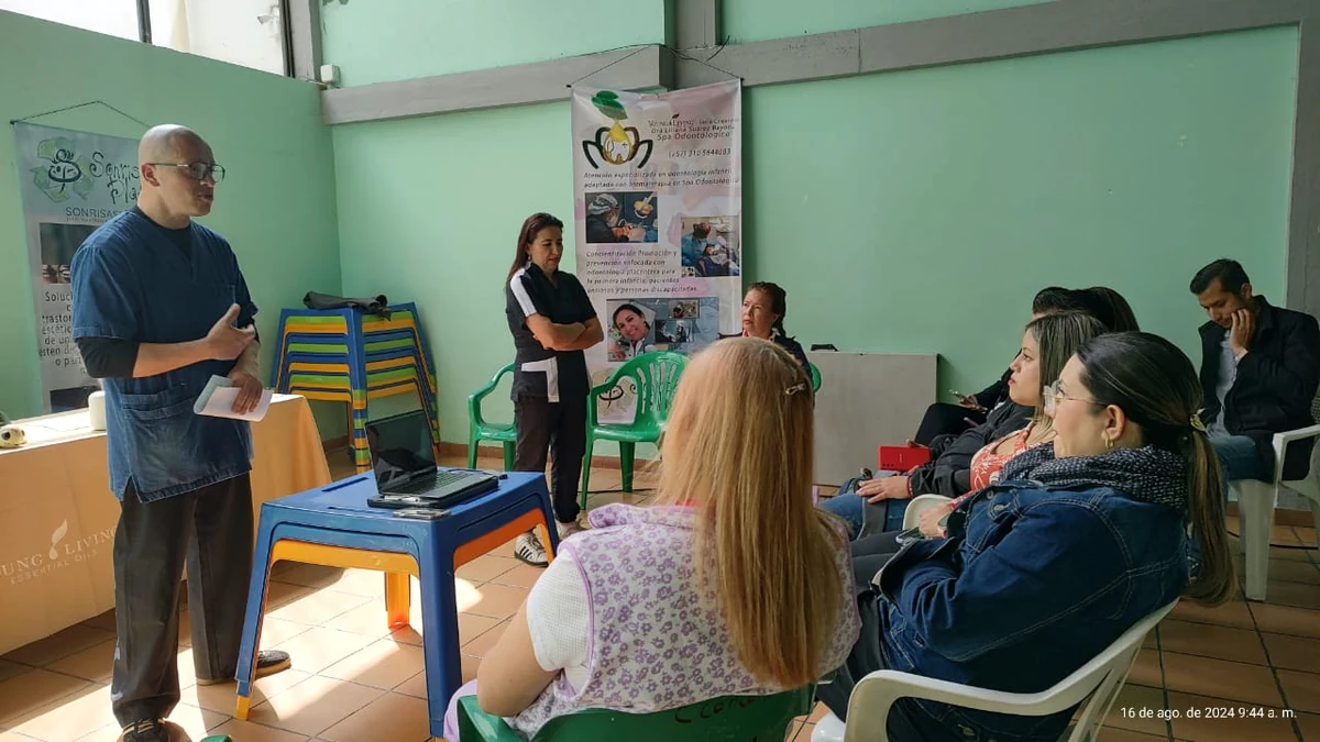 Vista general de una charla con asistentes y material de salud oral.